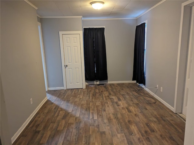 empty room with dark hardwood / wood-style flooring and crown molding