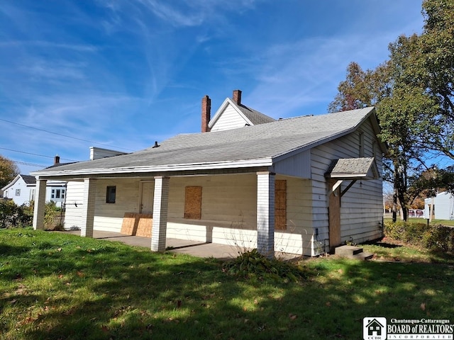 back of house featuring a lawn