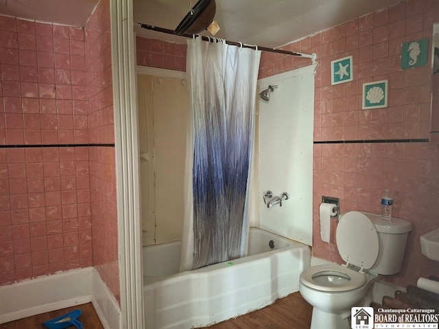 bathroom featuring toilet, shower / bathtub combination with curtain, tile walls, and hardwood / wood-style flooring