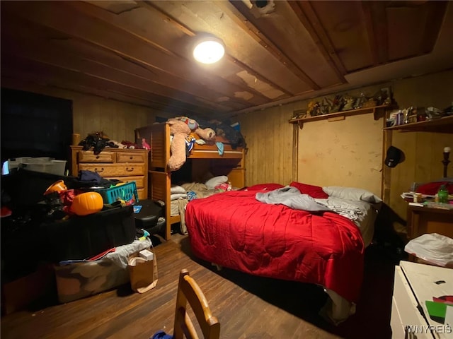 bedroom with wooden walls and hardwood / wood-style flooring