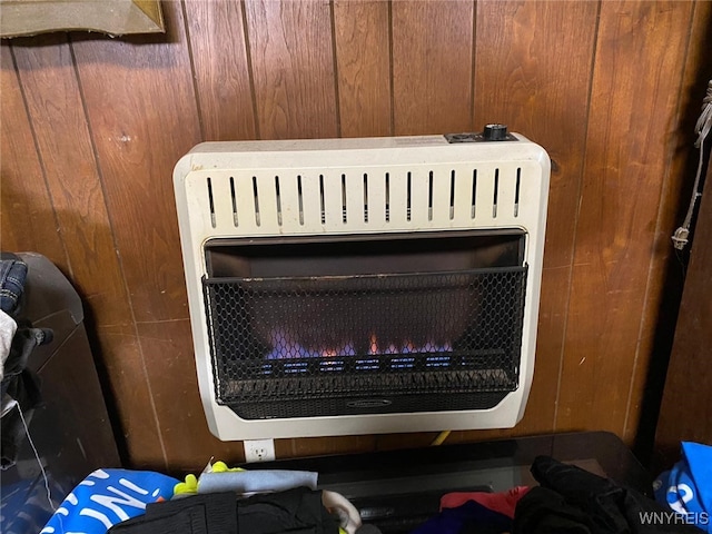 room details featuring heating unit and wooden walls