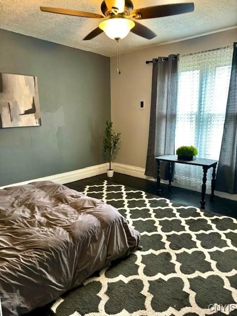 bedroom featuring ceiling fan and a textured ceiling