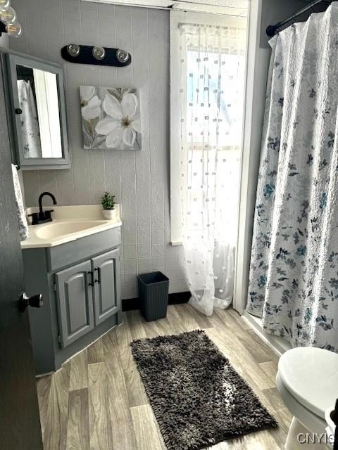 bathroom with vanity, hardwood / wood-style floors, curtained shower, and toilet