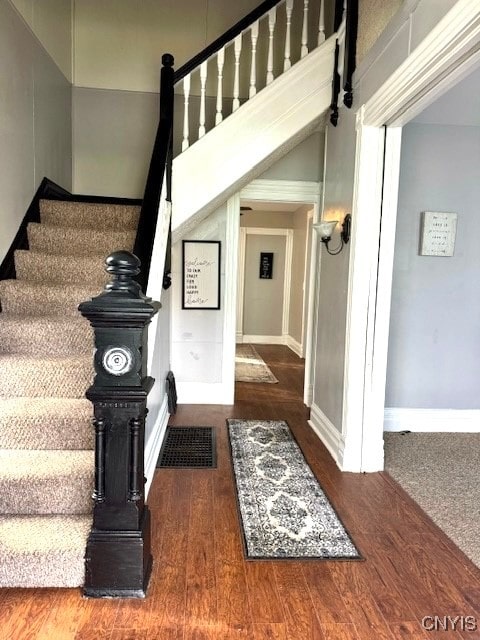 stairs featuring hardwood / wood-style floors