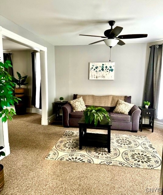 carpeted living room with ceiling fan