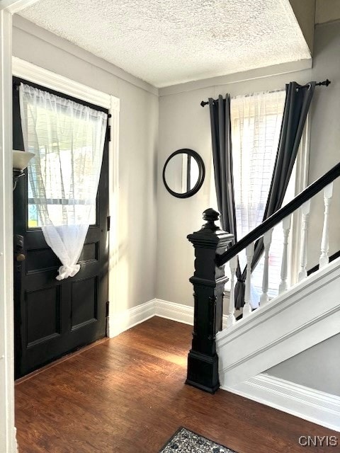 foyer with dark wood-type flooring and a textured ceiling