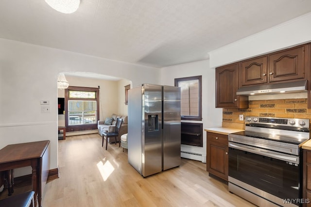 kitchen featuring tasteful backsplash, light wood-type flooring, appliances with stainless steel finishes, and a baseboard heating unit