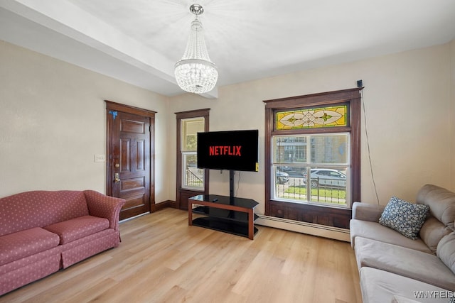 living room featuring a notable chandelier, light wood-type flooring, and baseboard heating