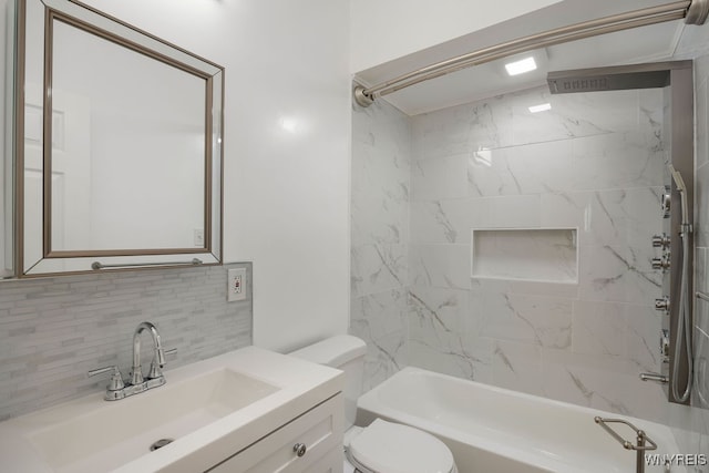 full bathroom with tasteful backsplash, toilet, vanity, and tiled shower / bath