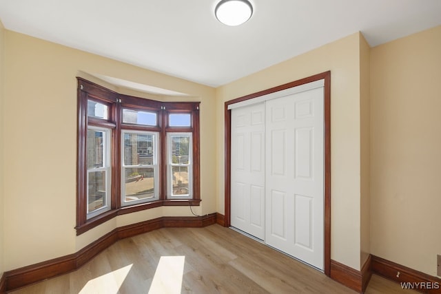 unfurnished bedroom featuring light hardwood / wood-style floors and a closet