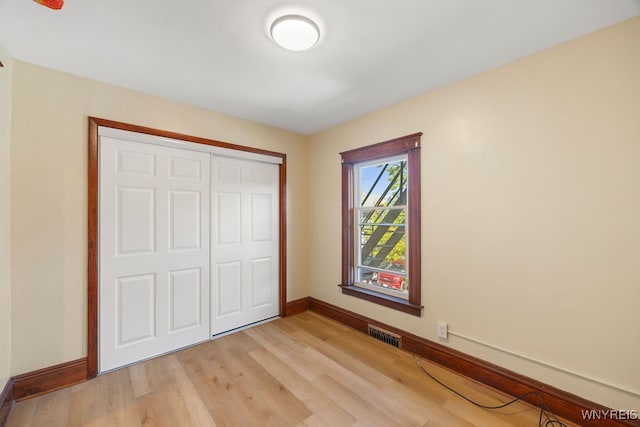 unfurnished bedroom with a closet and light hardwood / wood-style flooring