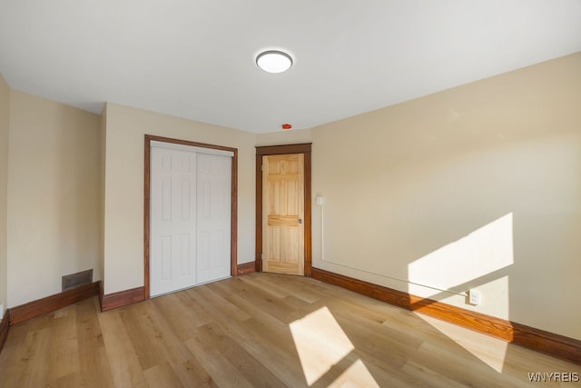 unfurnished bedroom featuring light wood-type flooring and a closet