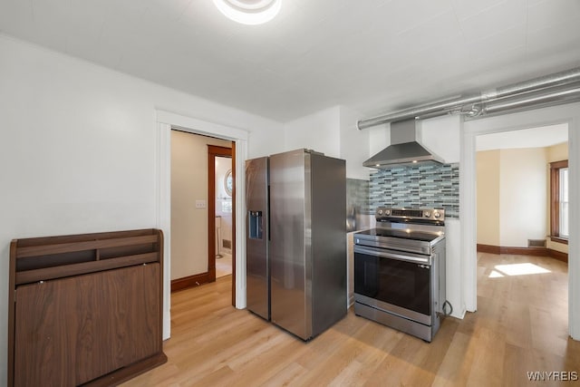 kitchen featuring decorative backsplash, appliances with stainless steel finishes, light hardwood / wood-style flooring, and wall chimney range hood