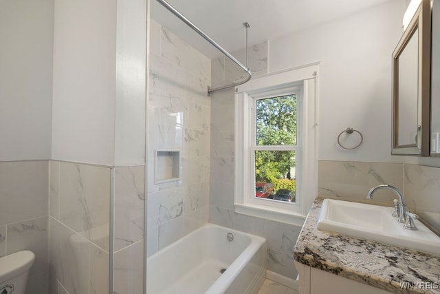 full bathroom featuring vanity, toilet, and tile walls