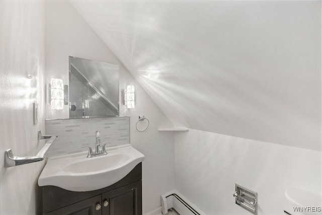 bathroom featuring vanity, lofted ceiling, and tasteful backsplash