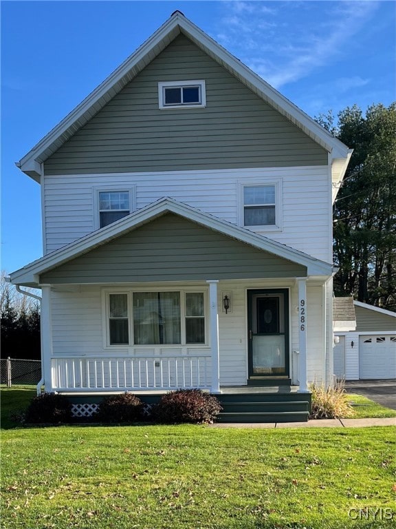 view of property with an outbuilding, a garage, and a front lawn