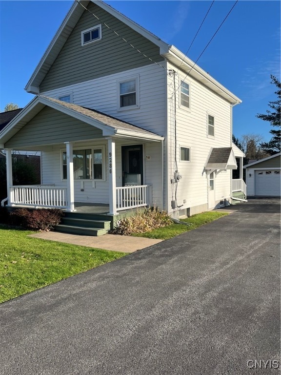 front facade featuring a porch, a garage, and an outdoor structure