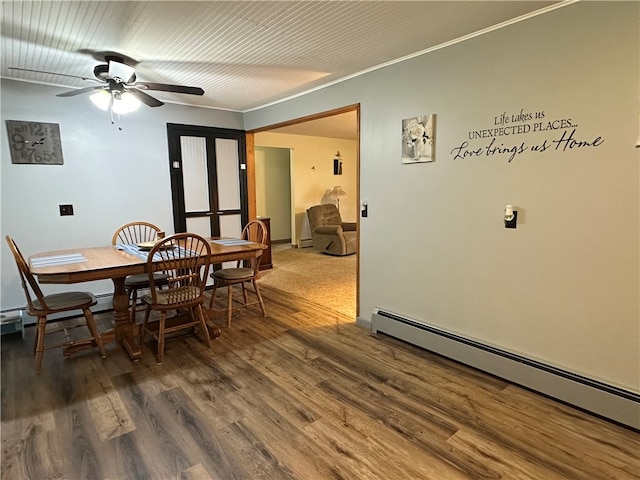 dining area featuring hardwood / wood-style flooring, ceiling fan, and a baseboard heating unit