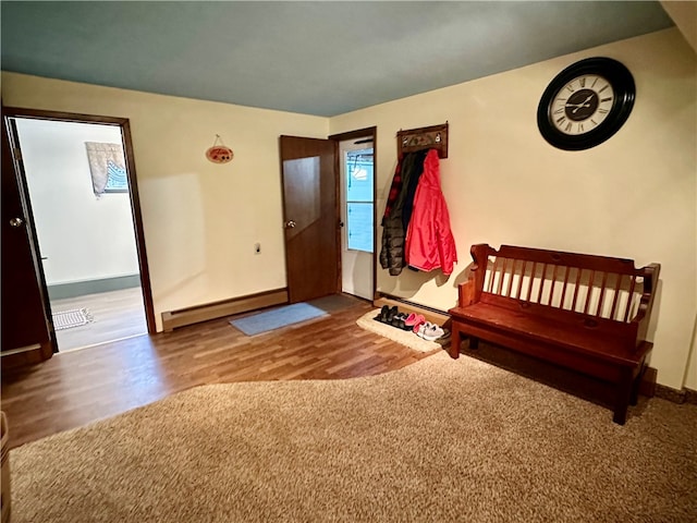 unfurnished bedroom with hardwood / wood-style flooring and a baseboard heating unit