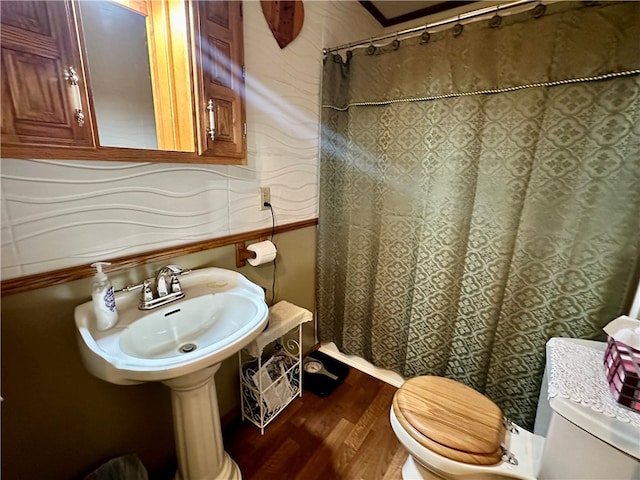 bathroom with hardwood / wood-style flooring, a shower with shower curtain, and toilet