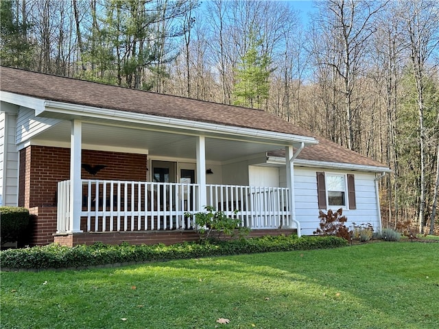 ranch-style house featuring covered porch and a front lawn