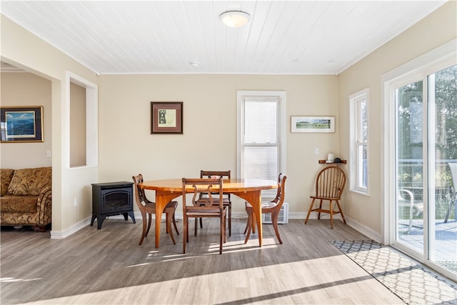 dining area featuring a wood stove, wood ceiling, and light hardwood / wood-style flooring