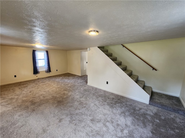 basement with dark colored carpet and a textured ceiling