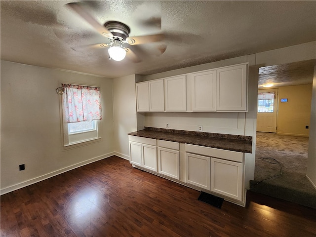 kitchen featuring a textured ceiling, ceiling fan, white cabinets, and dark hardwood / wood-style floors