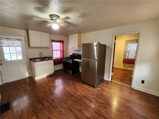 kitchen featuring white cabinets, black range with gas cooktop, stainless steel refrigerator, and dark wood-type flooring