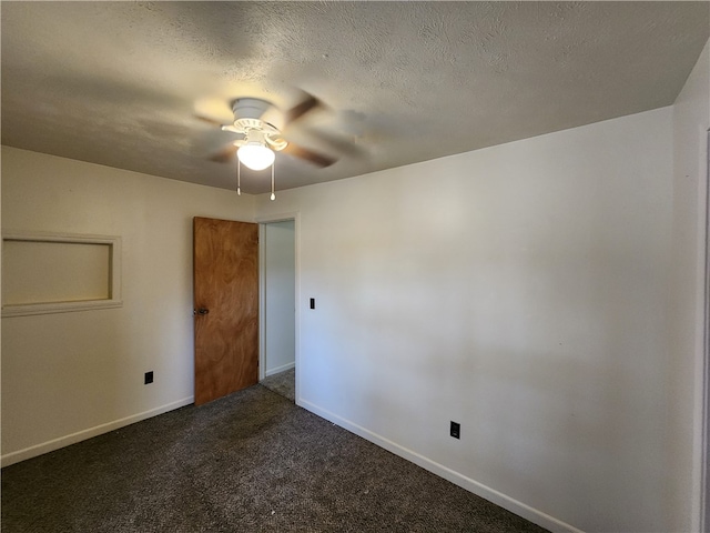 empty room with dark colored carpet, a textured ceiling, and ceiling fan