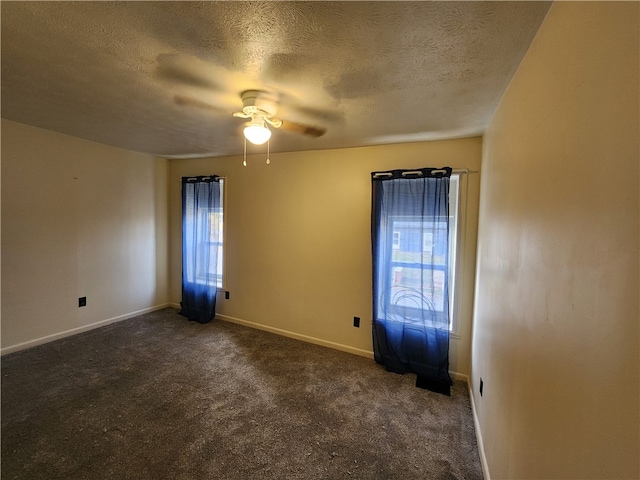 carpeted spare room with a textured ceiling, a wealth of natural light, and ceiling fan