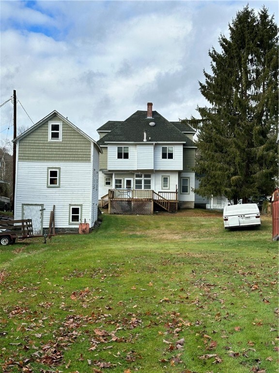 back of house featuring a deck and a yard