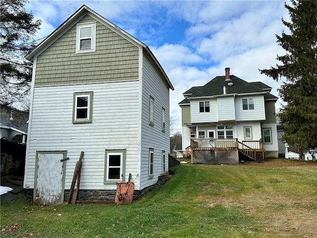 rear view of property with a deck and a lawn