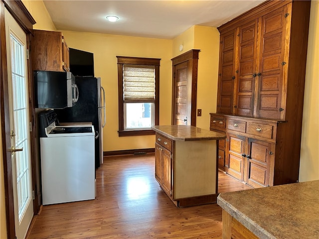 kitchen with white range oven, a center island, and light wood-type flooring