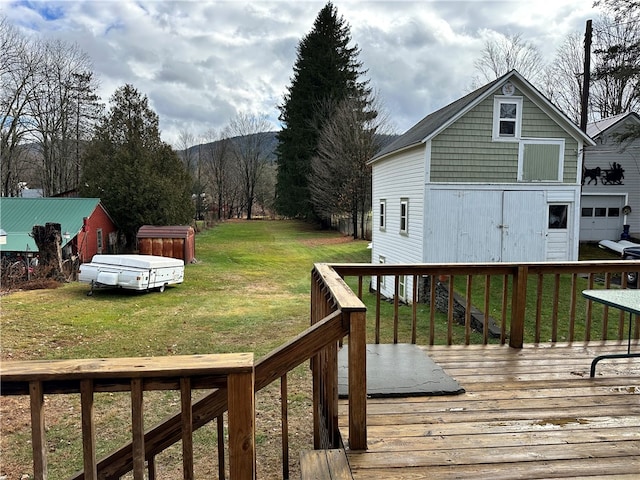 wooden deck featuring a mountain view and a lawn