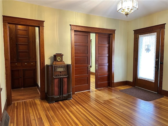 foyer featuring a chandelier and wood-type flooring