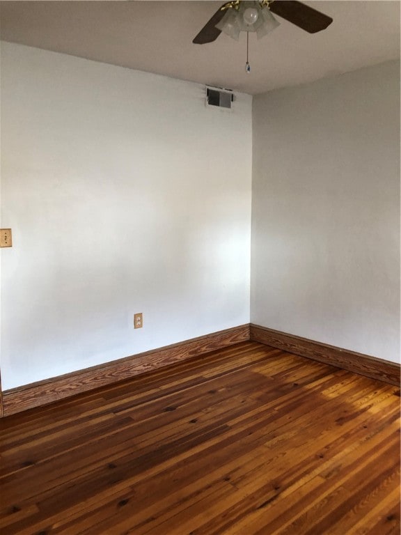 empty room with ceiling fan and dark wood-type flooring