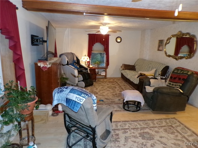 living room with beamed ceiling, hardwood / wood-style flooring, and ceiling fan