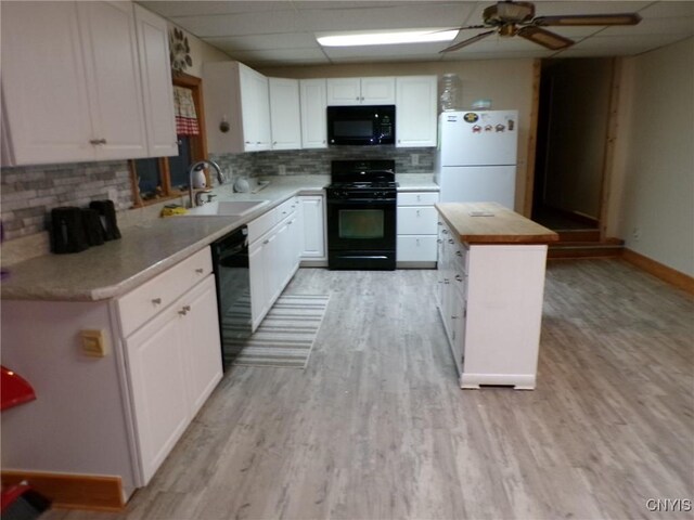 kitchen featuring black appliances, white cabinetry, and wooden counters