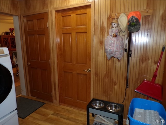 interior space featuring wooden walls, washer / clothes dryer, and light hardwood / wood-style flooring