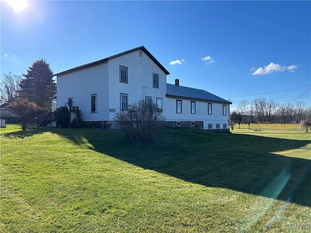 rear view of house featuring a yard