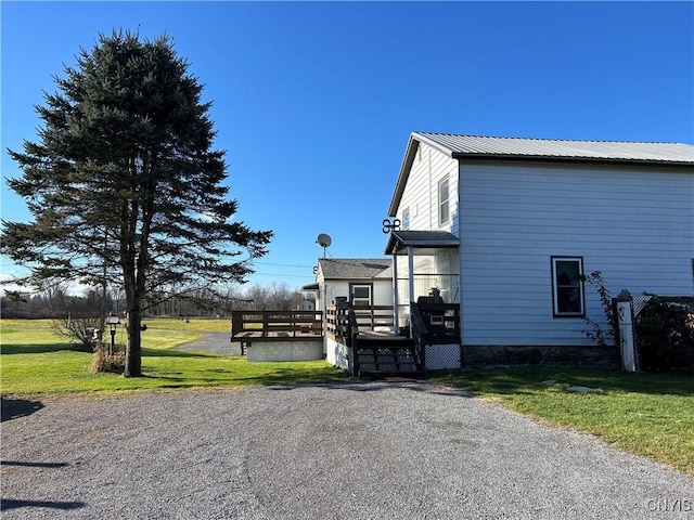 view of property exterior featuring a wooden deck and a lawn