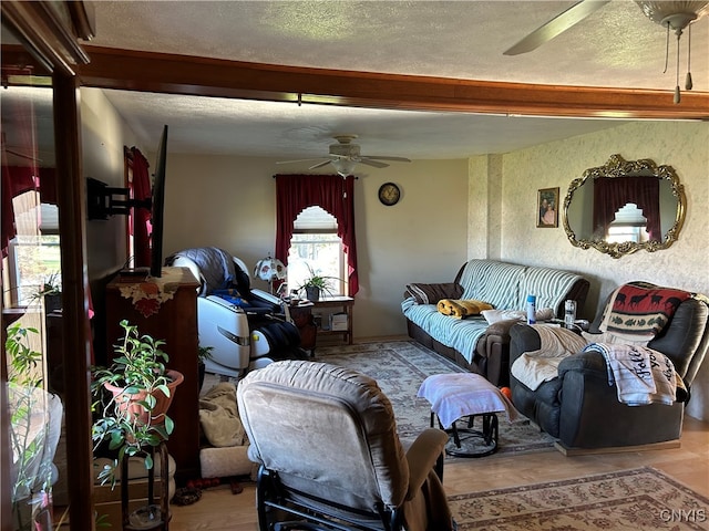 living room featuring ceiling fan, a textured ceiling, and hardwood / wood-style flooring