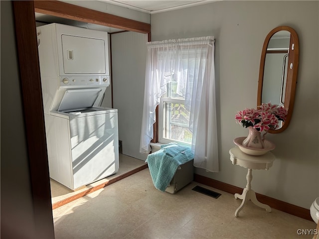 clothes washing area featuring stacked washer and clothes dryer