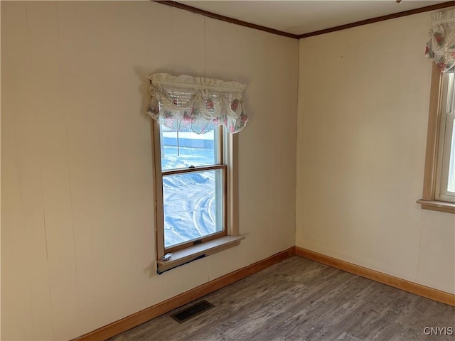 unfurnished room featuring crown molding and wood-type flooring