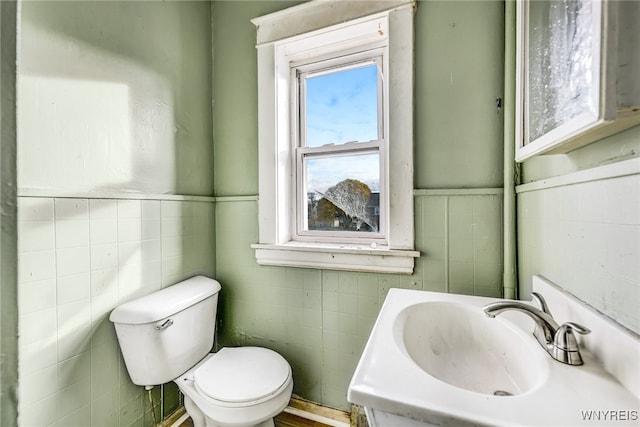 bathroom featuring sink, tile walls, and toilet