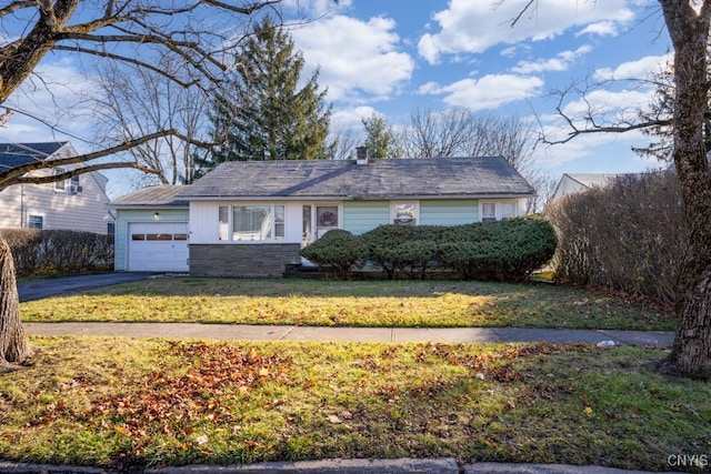 ranch-style house with a garage and a front lawn