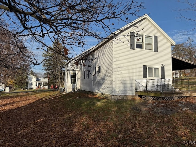 view of side of home with a lawn and a wooden deck