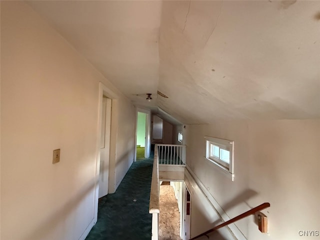 corridor featuring carpet floors and vaulted ceiling