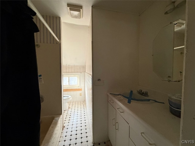 bathroom with sink, tile walls, and toilet